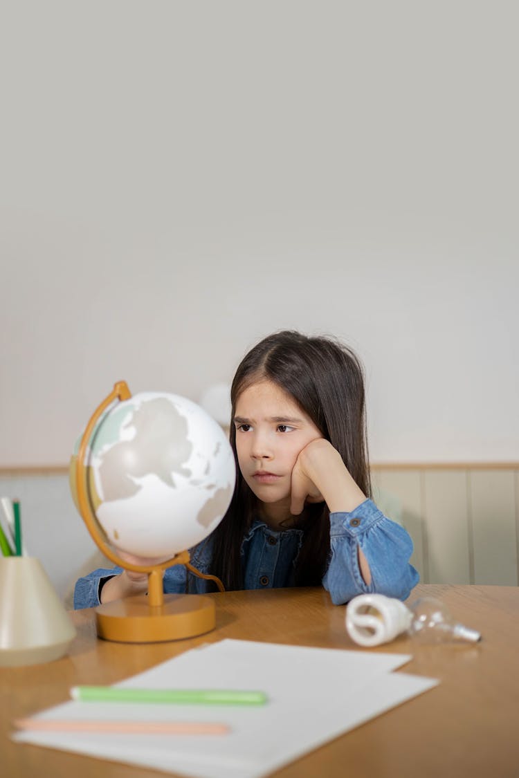 A Bored Girl Looking At A Globe