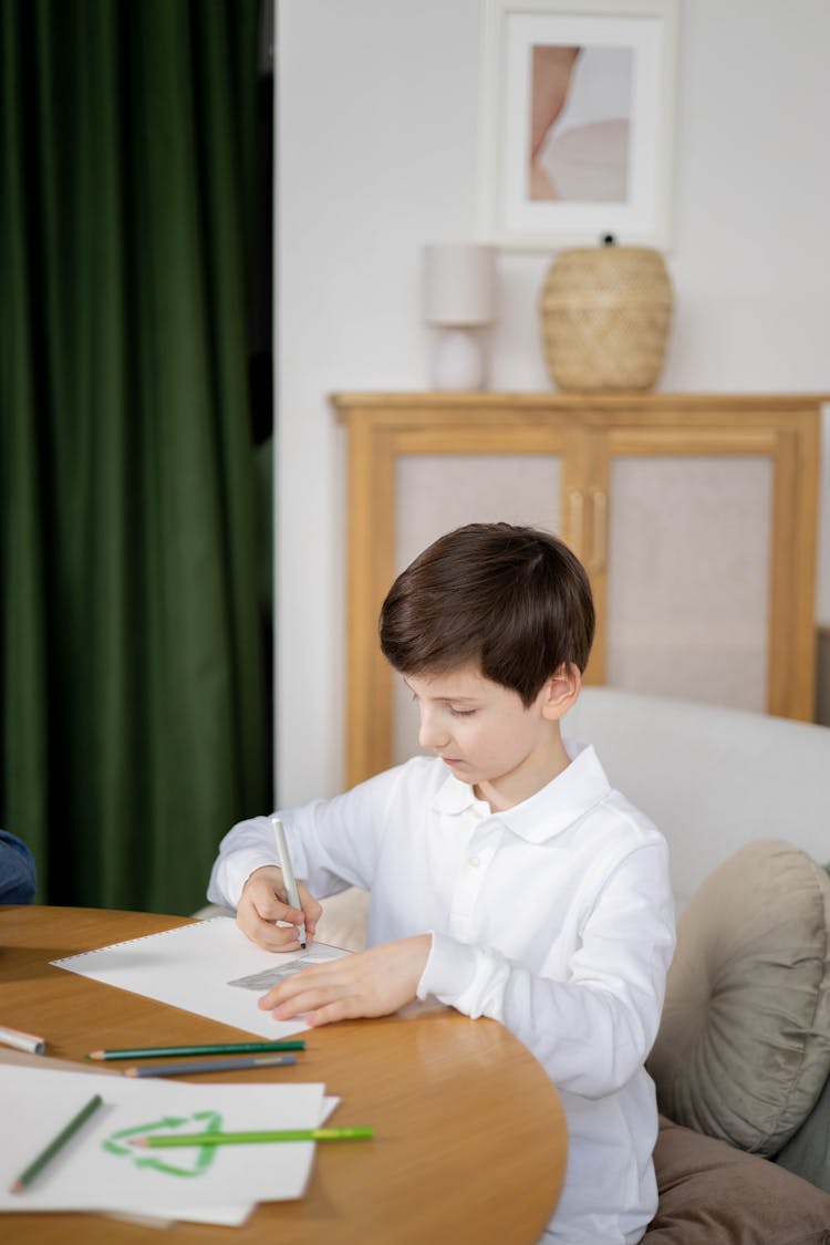 A Boy Writing On A Paper