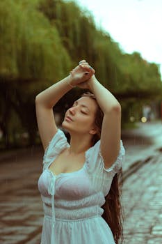 A serene woman in a white dress savors the rain in a leafy street in Curitiba, Brazil.