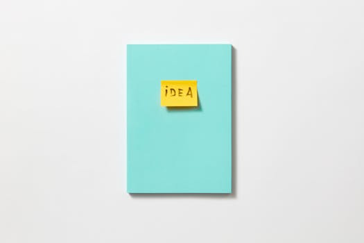 Yellow sticky note with 'idea' on a teal book, symbolizing creativity and inspiration.