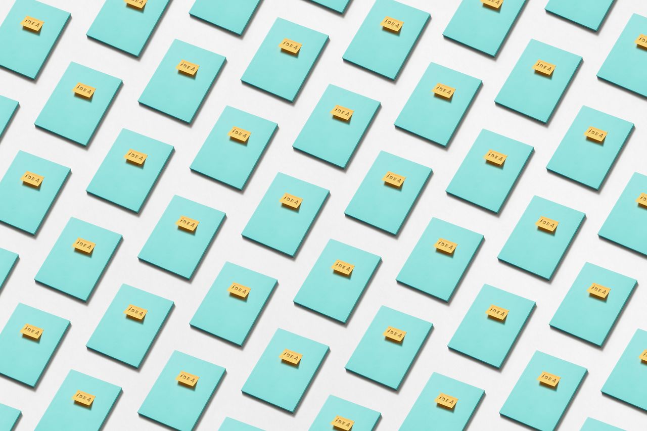 a conceptual pattern of blue notebooks and yellow sticky notes reading