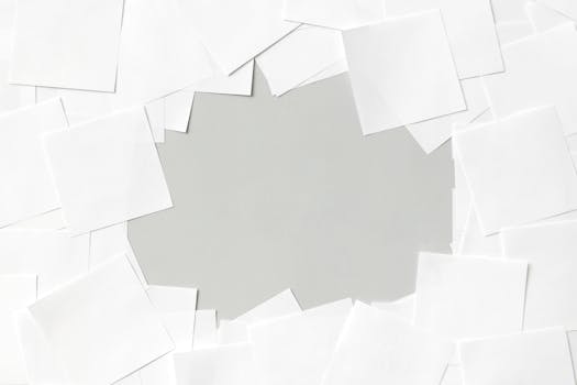 A minimal abstract background featuring overlapping white paper sheets.
