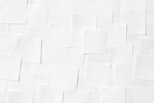 Overhead view of white square papers layered in a minimalist design.
