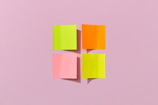 Vibrant sticky notes arranged on a pastel pink surface, perfect for creative projects.