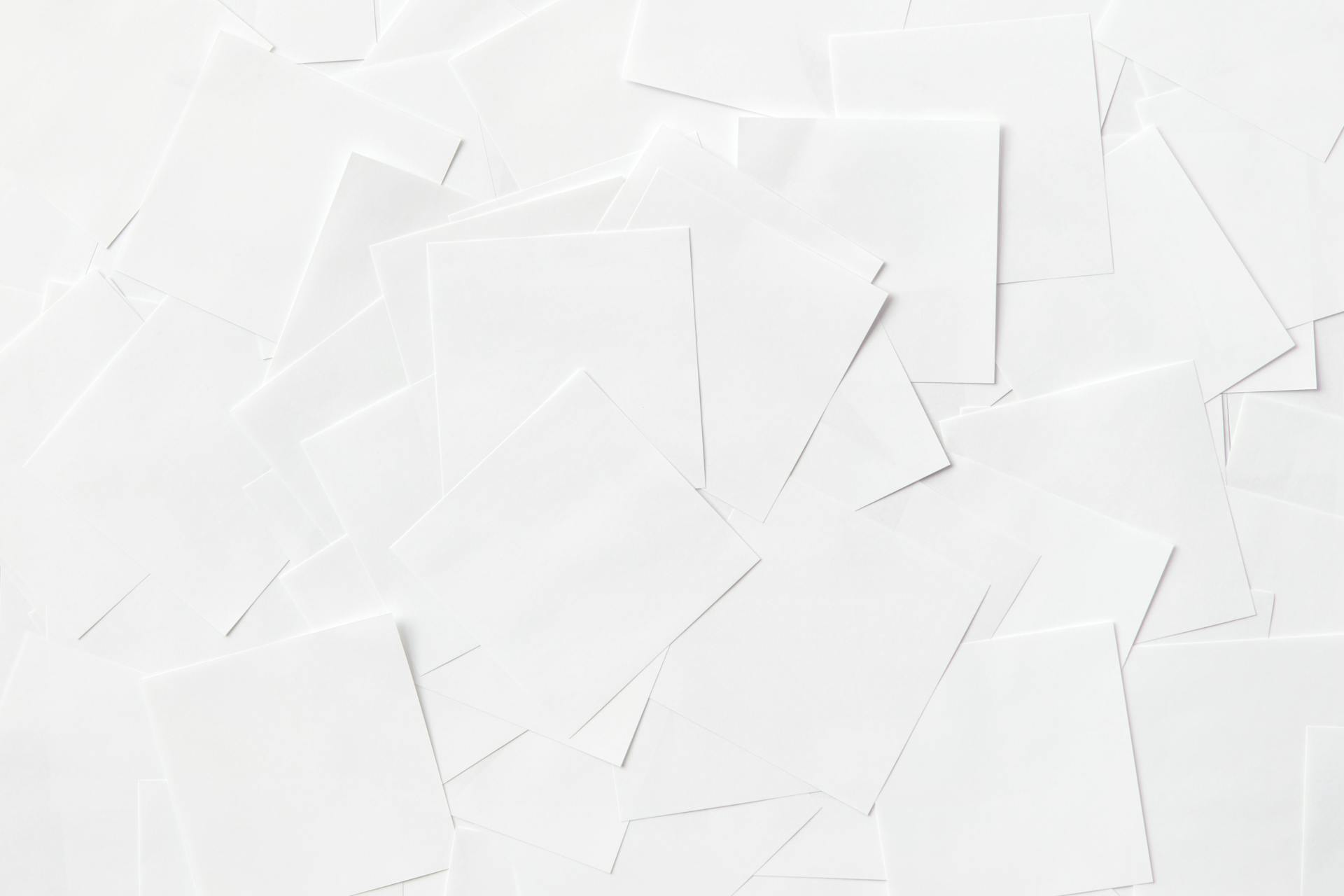 Clean Sheets of White Paper Scattered on Surface