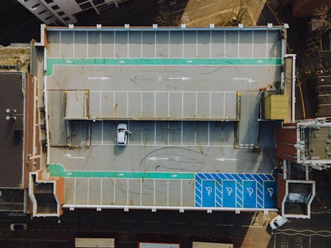 Drone shot of a rooftop parking lot with a single white car in Kingston upon Thames, England.