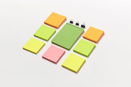 Sticky Notepads and Binder Paper Clips on White Surface