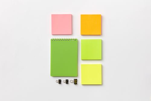 Free Top view of colorful stationery items including notepad and sticky notes on a white surface. Stock Photo