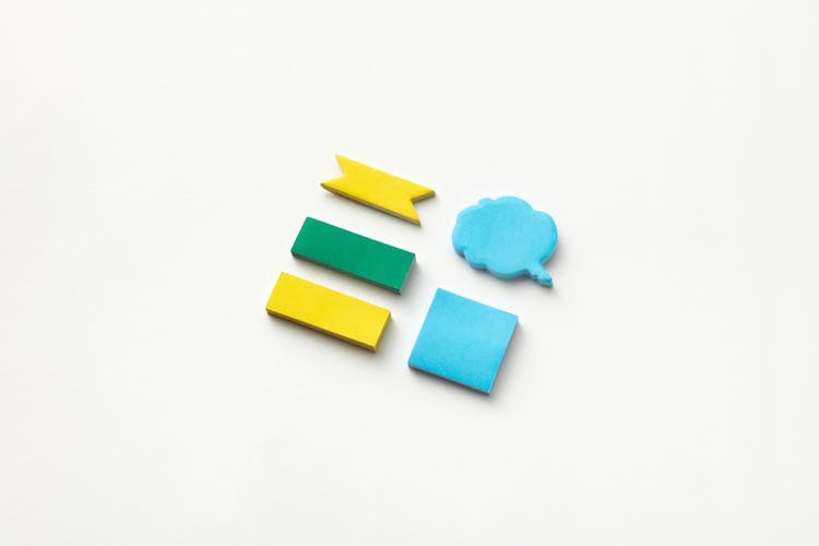 Assorted Sticky Note Pads With A Cloud Speech Bubble Pad On A White Surface