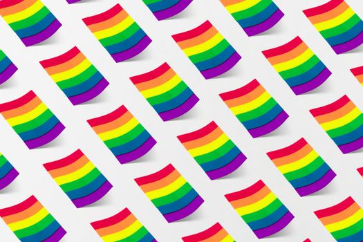 A vibrant pattern of rainbow flags symbolizing LGBTQ pride against a white backdrop.