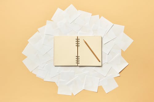 Spiral Notepad with Pencil on Scattered Sticky Notes