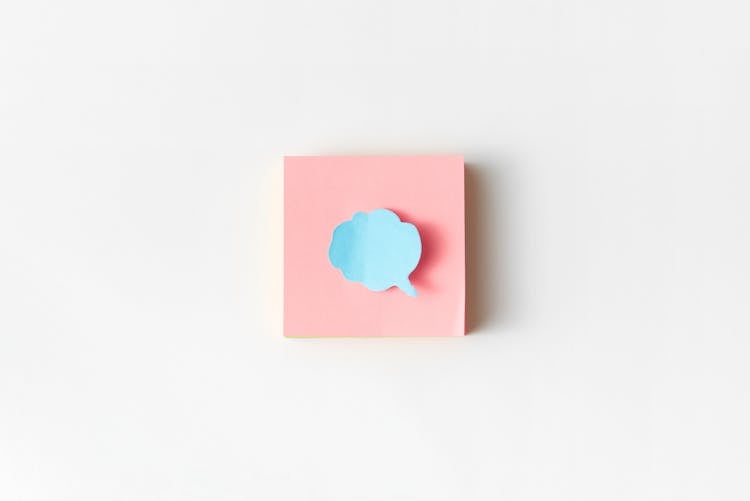 A Blue Cloud Speech Bubble On A Pink Sticky Note