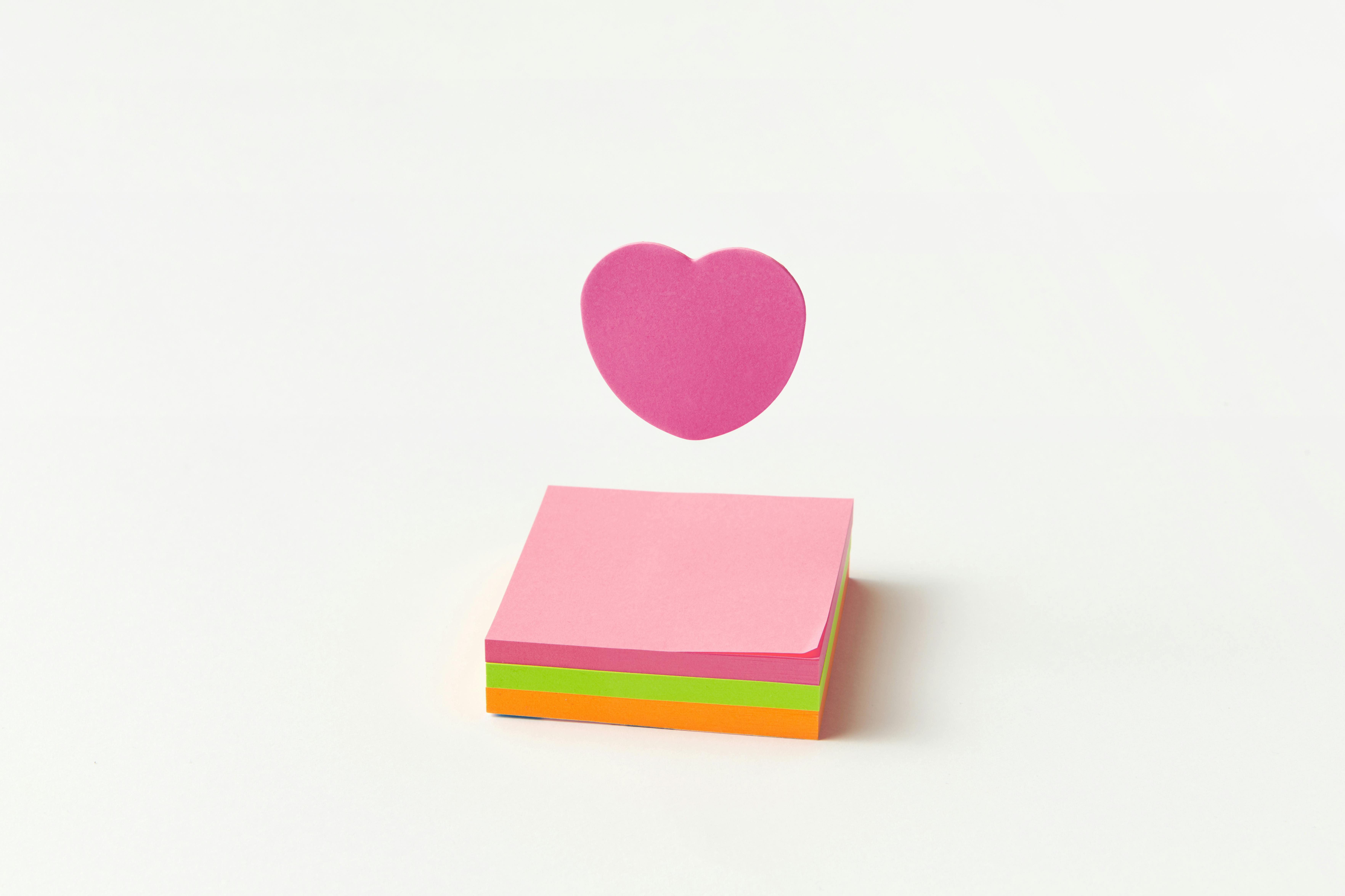 A Purple Heart Shaped Sticky Note Over a Pad of Square Sticky Notes · Free  Stock Photo