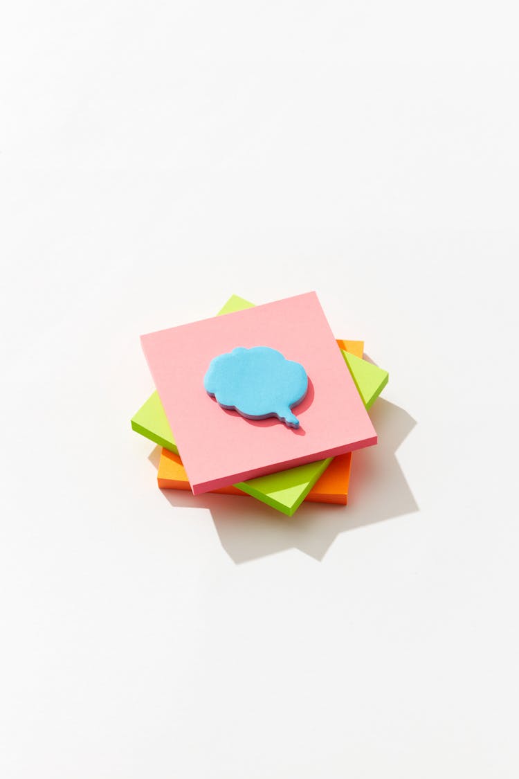 A Speech Bubble Sticky Note Pad On A Stack Of Sticky Note Pads