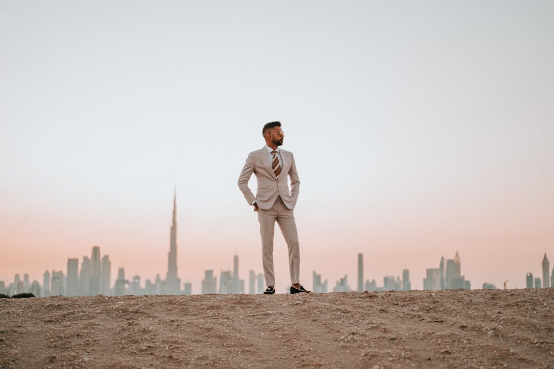 Man in Beige Suit Standing on Brown Sand