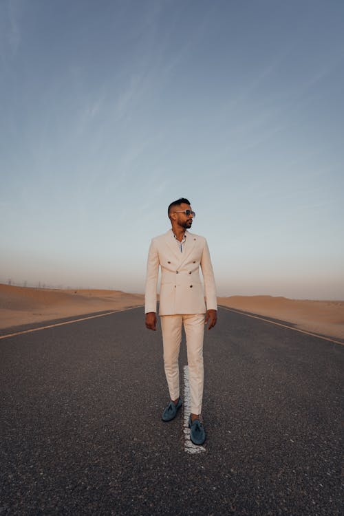 Man in White Suit Standing on Road