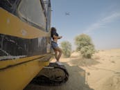 A Sexy Woman Standing on a Grouser Pad of a Heavy Equipment Flying a Drone