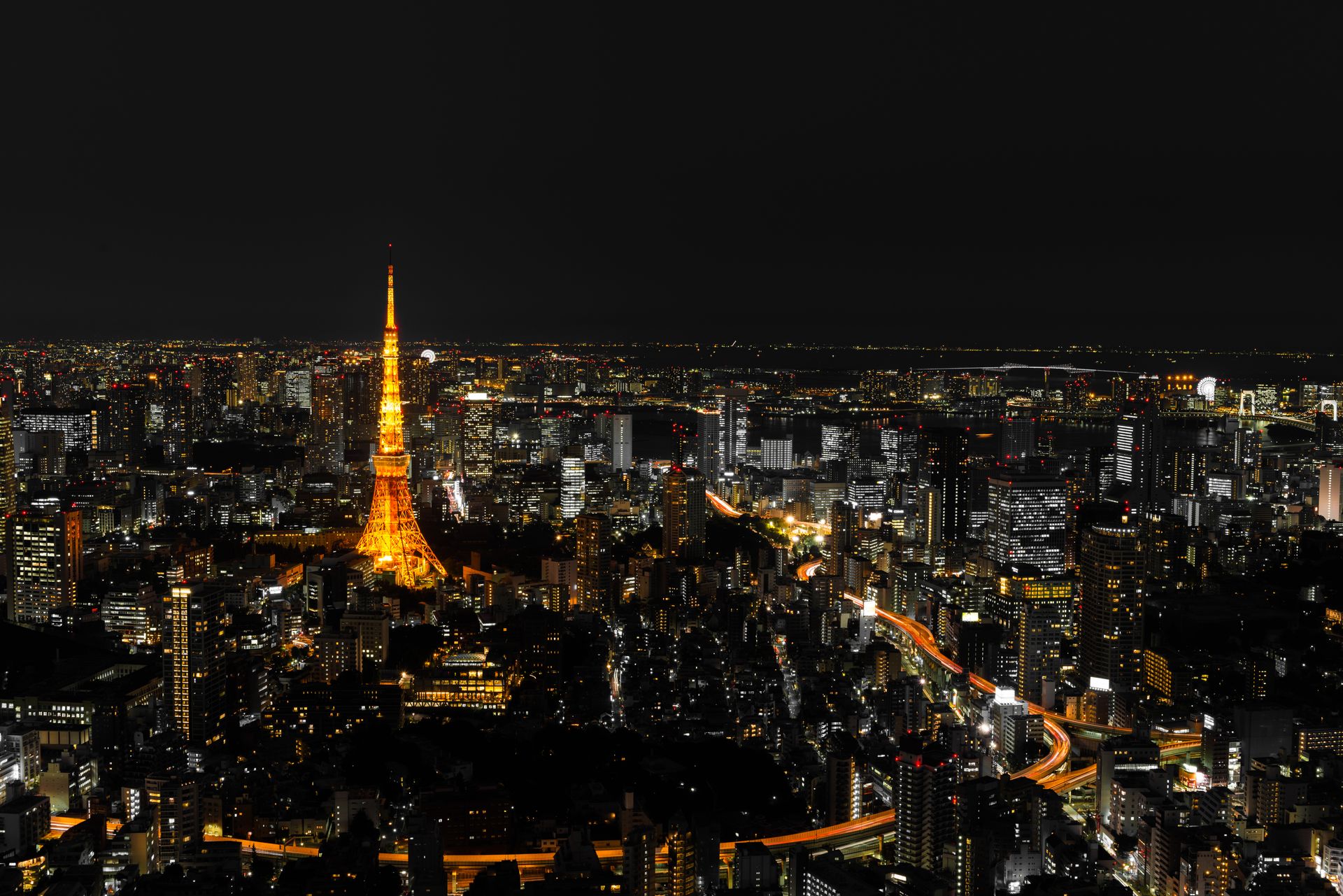 A breathtaking view of Tokyo's night skyline featuring the illuminated Tokyo Tower prominently amidst the city's high-rises.