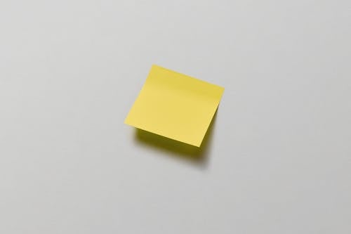 A Yellow Sticky Note on White Surface