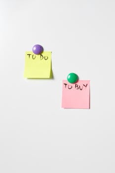 Sticky notes with reminders held by magnets on a white surface.