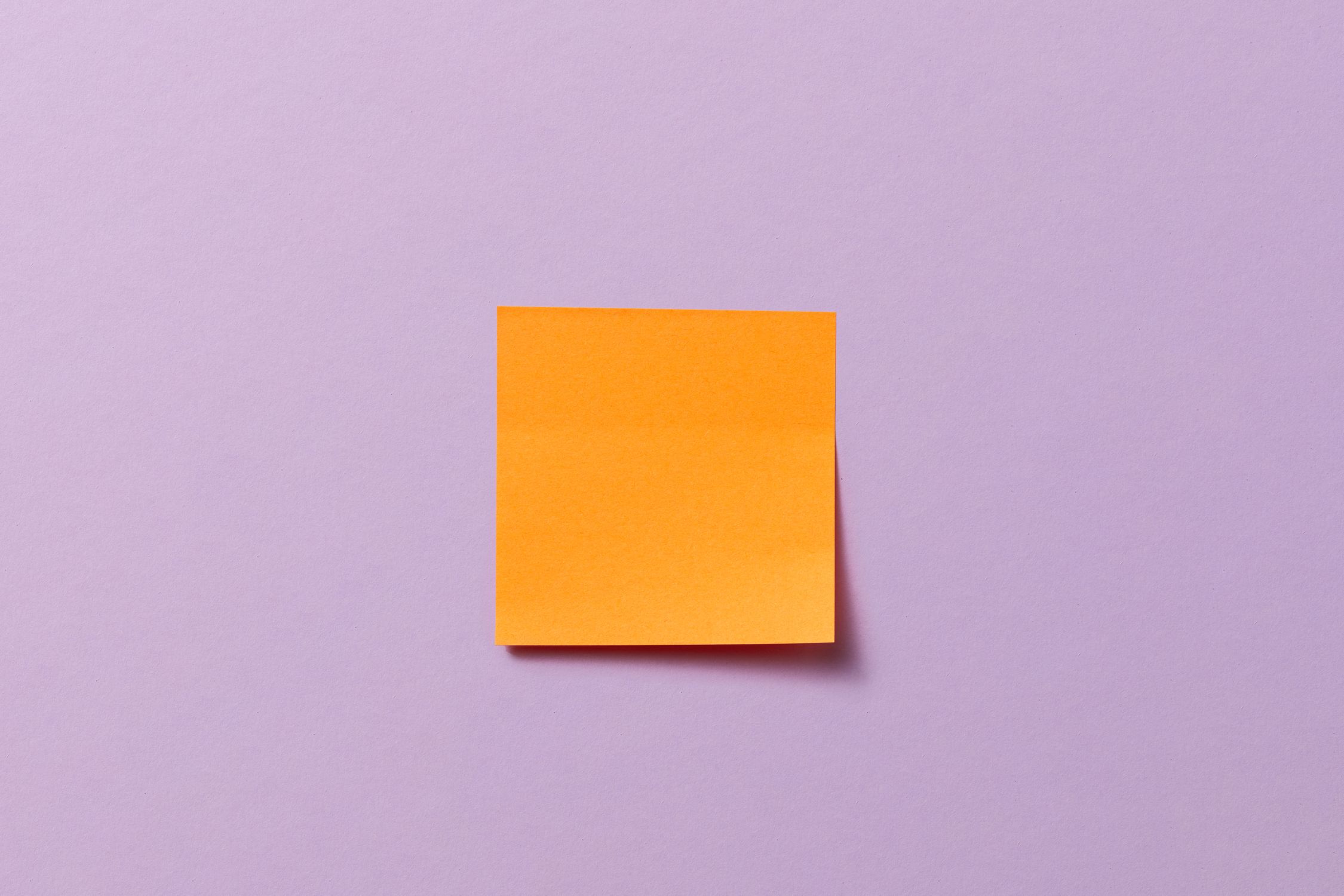 A Blank Sticky Note Stuck on a Lilac Surface · Free Stock Photo