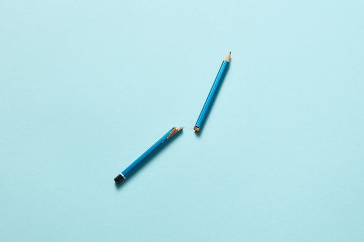 A Broken Pencil On A Light Blue Surface