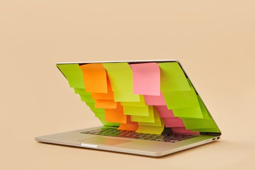 Free An Arrangement of Blank Sticky Notes Covering the Screen of a Partially Closed Laptop Stock Photo