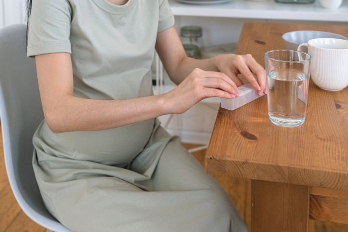 Pregnant woman taking prenatal vitamins