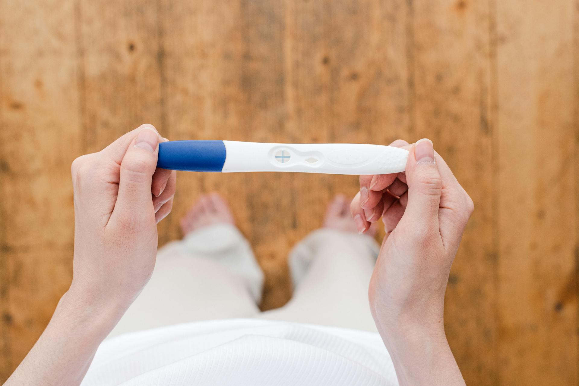 Crop woman with pregnancy test