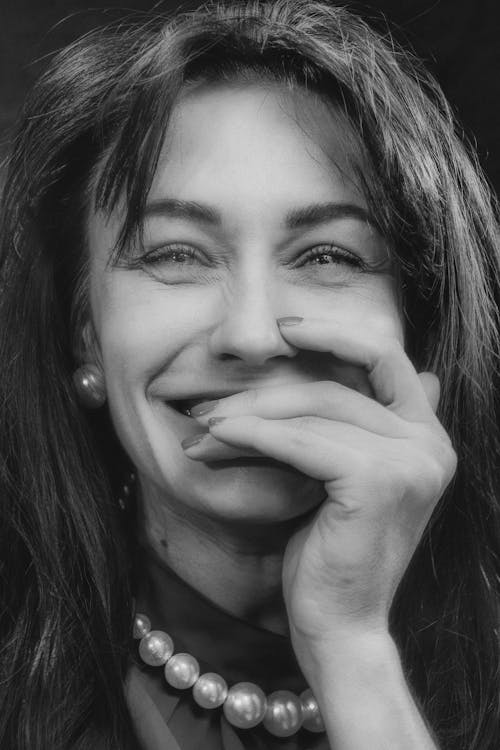A Grayscale Photo of a Smiling Woman