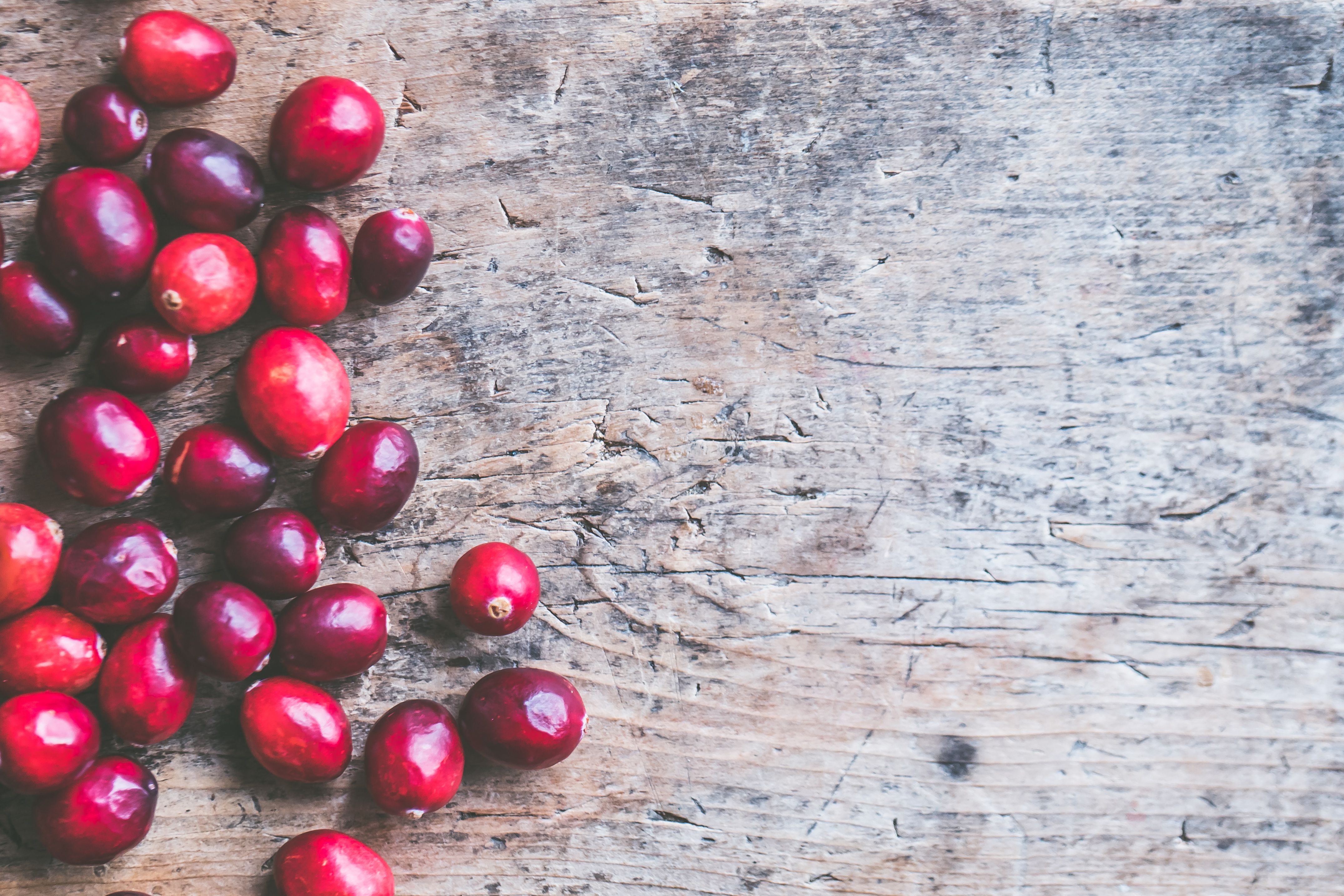 A fresh salad with raw cranberries mixed with leafy greens and nuts
