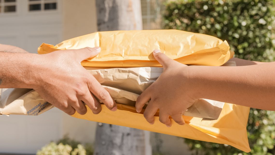 Customer handing a securely packed return parcel to a delivery professional