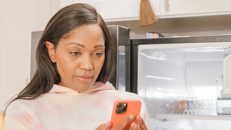 Photo Of A Woman Looking At Her Cell Phone