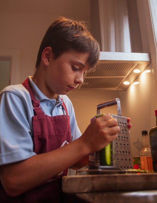 A Boy Using Grater