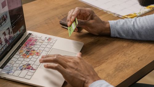 Free Close-up of hands using a laptop and holding a credit card for online shopping. Stock Photo