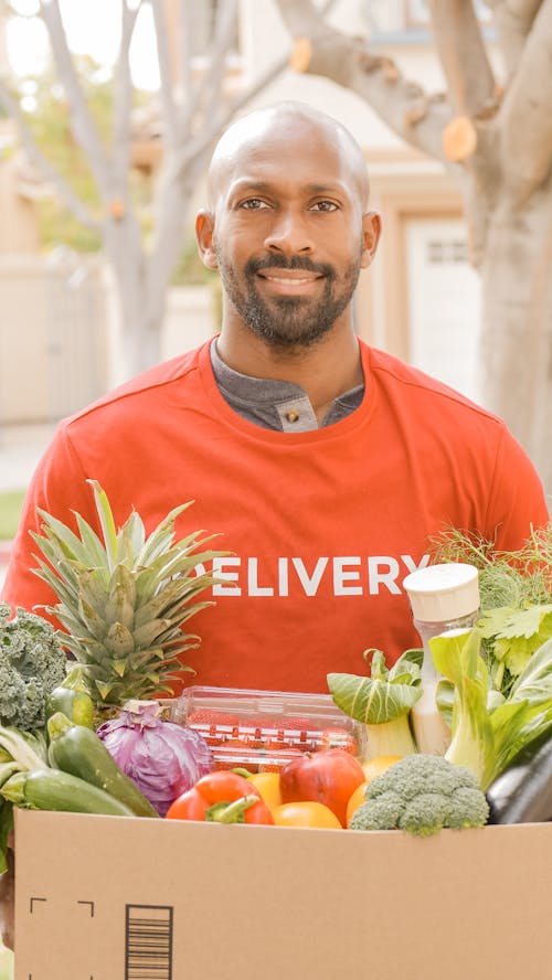 A Man Delivering a Grocery in a Box