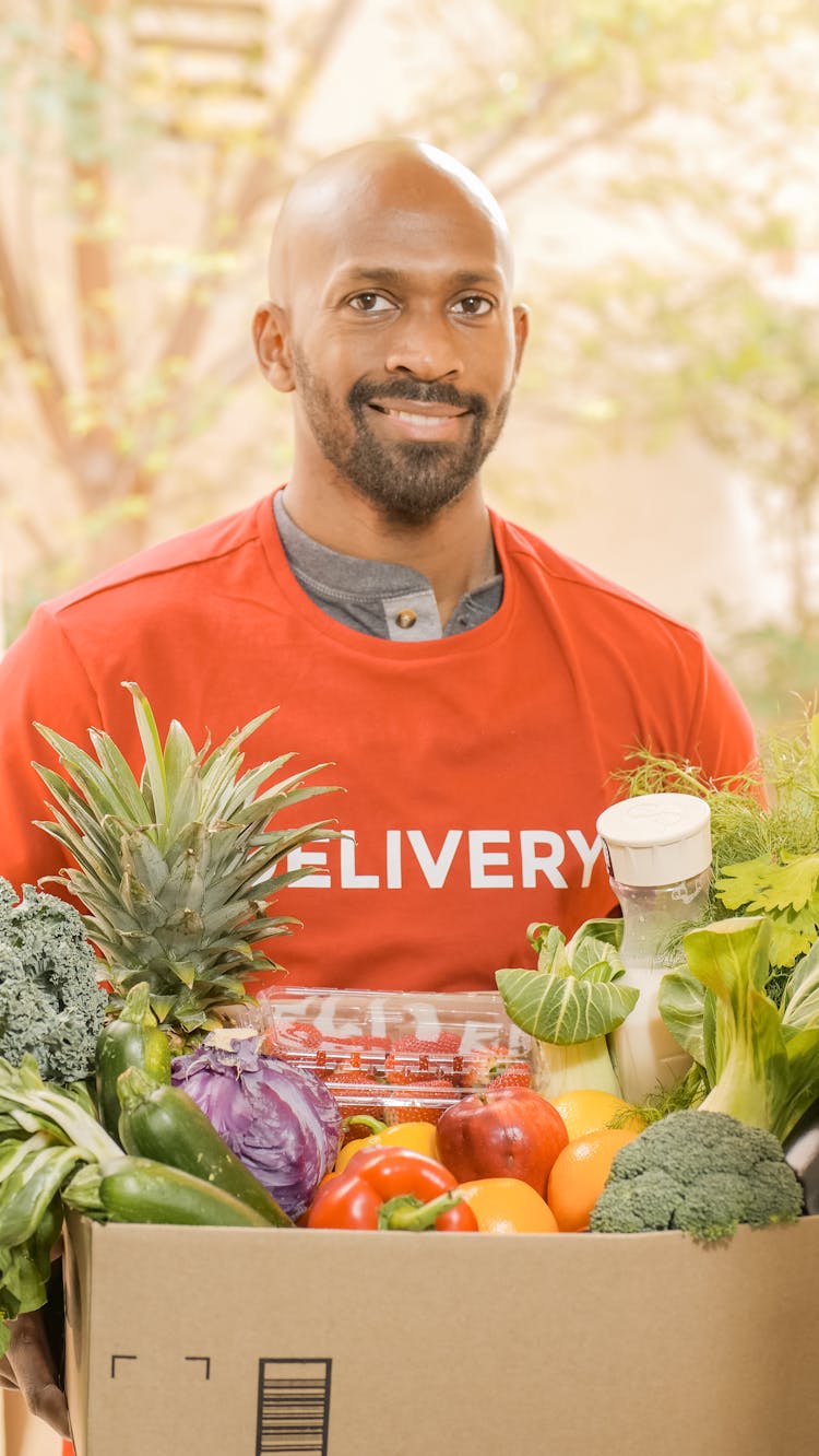 A Man Delivering A Grocery In A Box