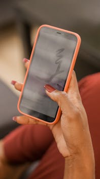 A person using a smartphone with manicured nails, showcasing online browsing indoors.