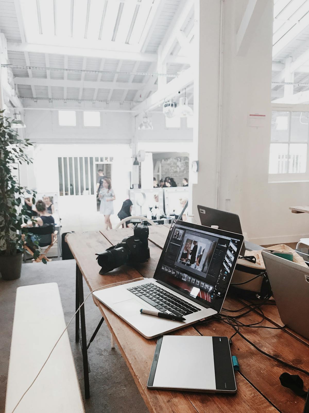 Laptop mit Bildbearbeitung und Kamera in kreativem Studio – schnelle Datenübertragung durch das 5G-Netz.