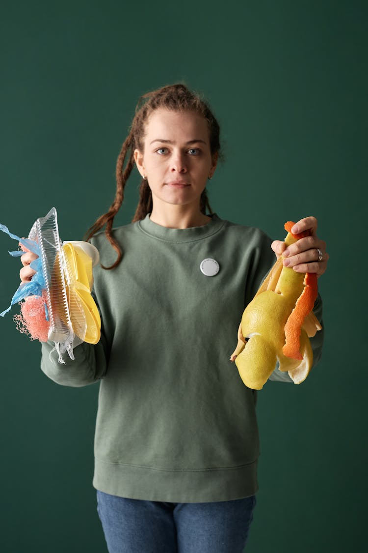 Woman Holding Plastic And Organic Trash In Hands