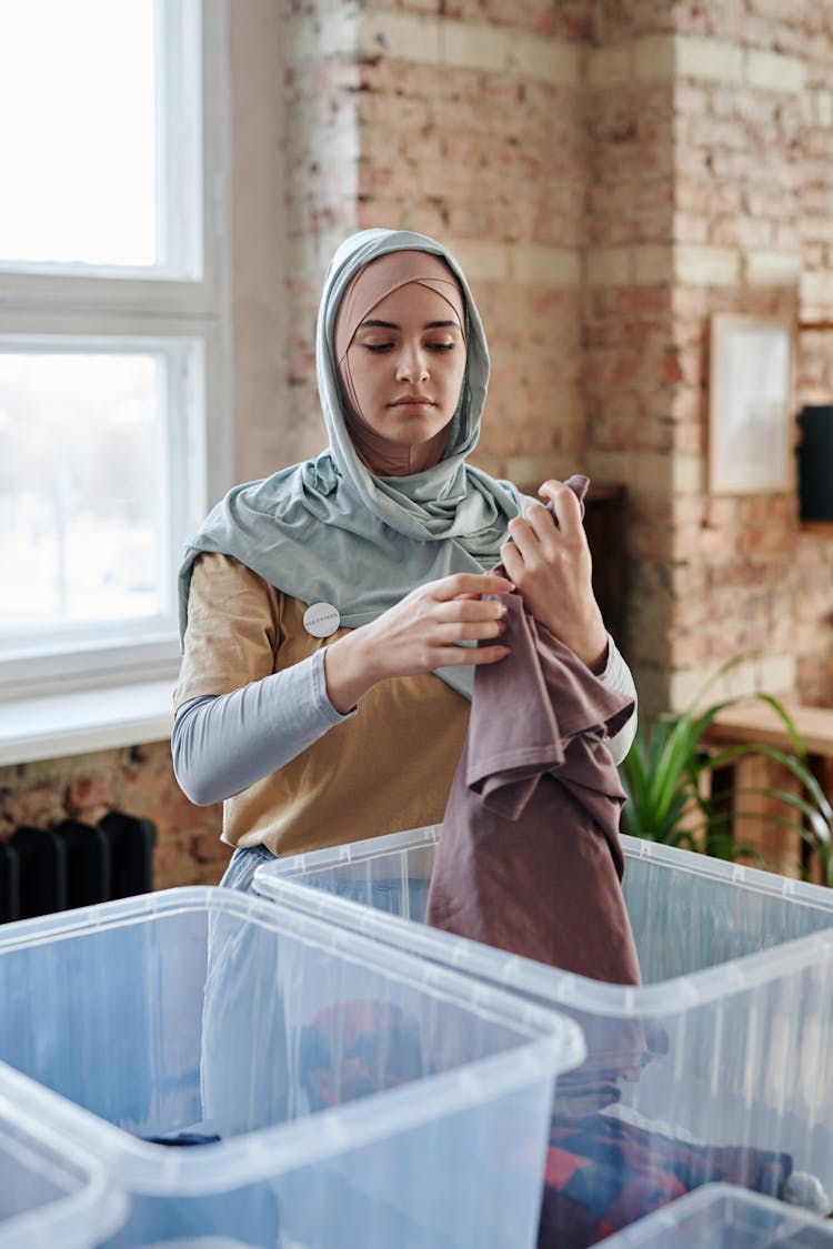 Woman In Hijab Sorting Clothes