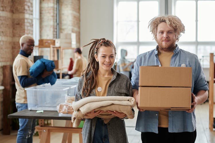 A Man And A Woman Holding Donations