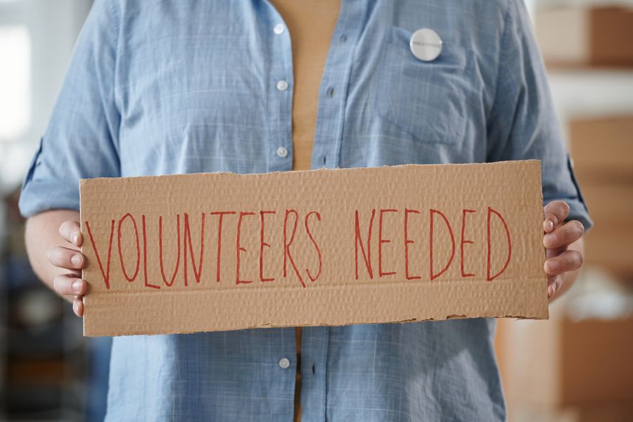 An older person being supported by a younger volunteer