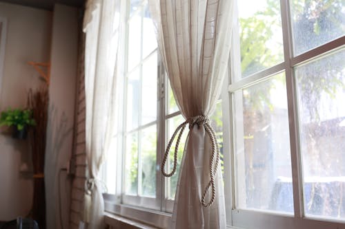 A Close-Up Shot of a Tied Curtain by the Window