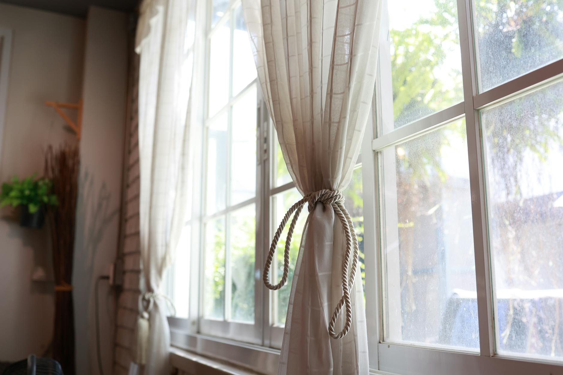 Curtains And Drapes Hanging By A Window With Sunlight Filtering Through