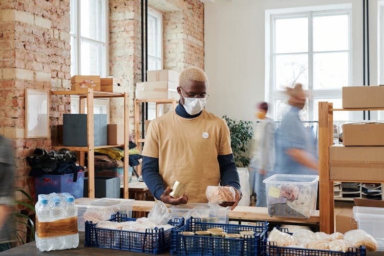 A Volunteer Wearing A Face Mask Preparing Donations