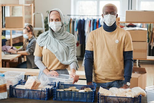 
Volunteers Wearing Face Masks in front of Donations