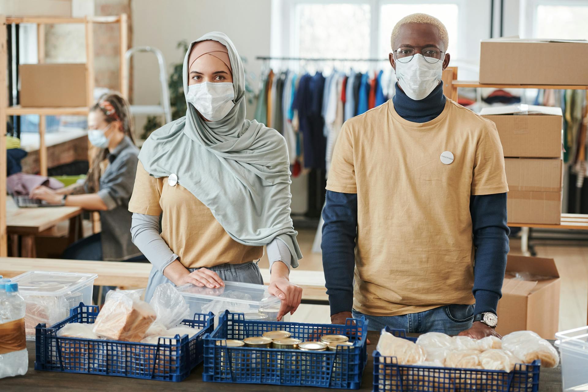 Volunteers Wearing Face Masks in front of Donations