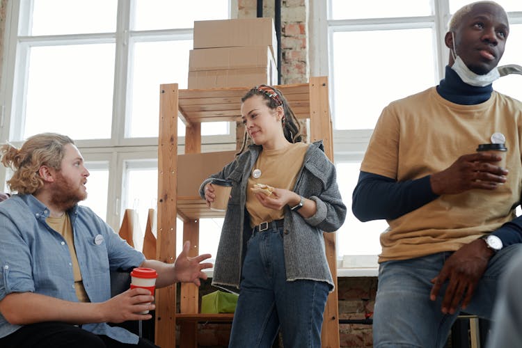 Men And Woman Eating Lunch And Drinking Coffee During A Break 