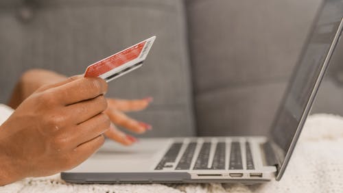 Person Holding Credit Card Doing Online Shopping